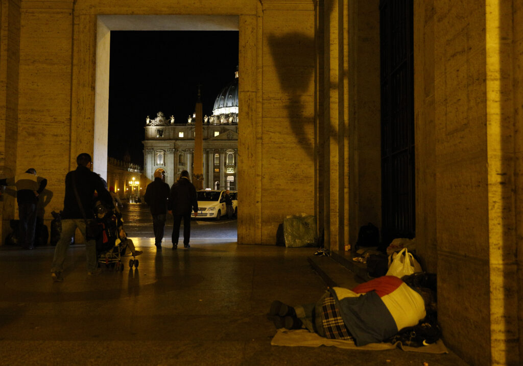 A homeless person sleeps outside the Vatican press office near St. Peter's Square Nov. 13. Public restrooms in St. Peter's Square will be renovated to include showers so the homeless can wash. Dozens of homeless people live within sight of the Vatican. (CNS photo/Paul Haring)