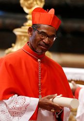 New Cardinal Arlindo Gomes Furtado of Santiago de Cabo Verde, Cape Verde, carries his scroll after receiving his red biretta from Pope Francis during a consistory at which the pope created 20 new cardinals in St. Peter's Basilica at the Vatican Feb. 14. (CNS photo/Paul Haring)