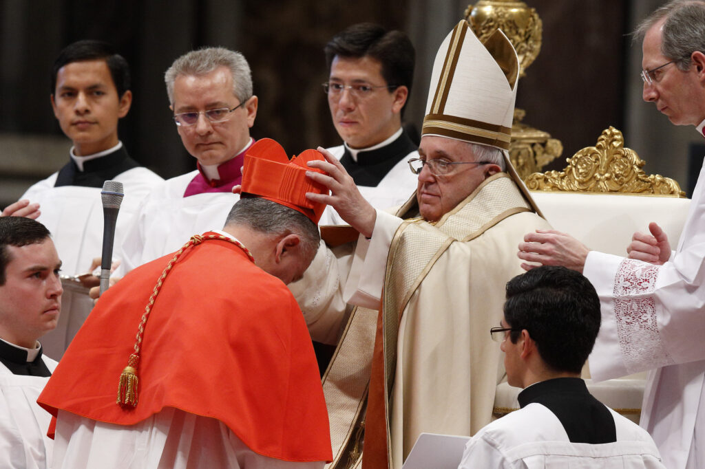 Pope Francis places a red biretta on new Cardinal John Dew of Wellington, New Zealand, during a consistory at which the pope created 20 new cardinals in St. Peter's Basilica at the Vatican Feb. 14. (CNS photo/Paul Haring)