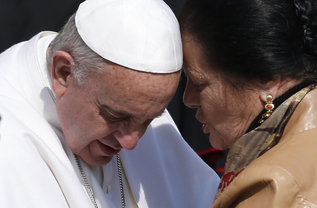Pope Francis listens to a woman while greeting the disabled during his general audience in St. Peter's Square at the Vatican March 11. (CNS photo/Paul Haring)
