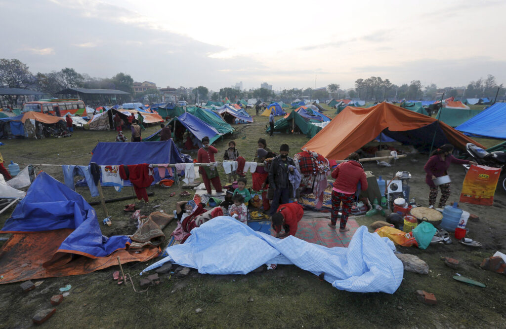 Earthquake survivors stand outside makeshift shelters in Kathmandu, Nepal, April 29. Inclement weather and logistical pressures have slowed down relief for victims of the April 25 earthquake. (CNS photo/Adnan Abidi, Reuters)
