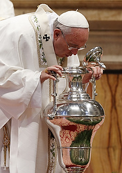 Pope Francis breathes over chrism oil, a gesture symbolizing the infusion of the Holy Spirit, during Holy Thursday chrism Mass in St. Peter's Basilica at the Vatican April 2. (CNS photo/Paul Haring)