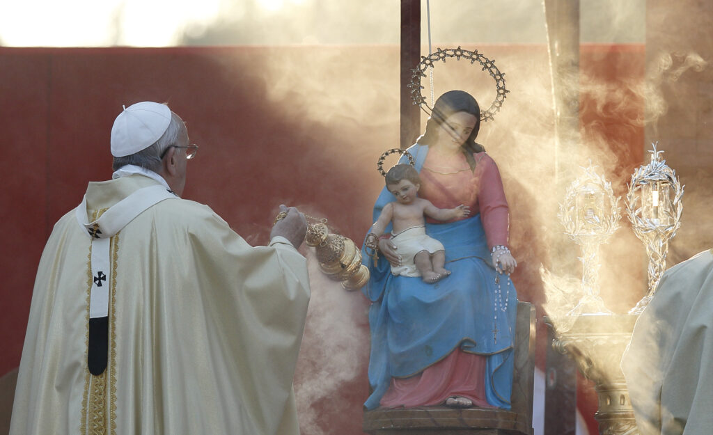 Pope Francis burns incense in front of a statue of Mary and relics of Sts. John XXIII and John Paul II as he celebrates Mass at the Verano cemetery in Rome Nov. 1, the feast of All Saints. (CNS photo/Paul Haring)