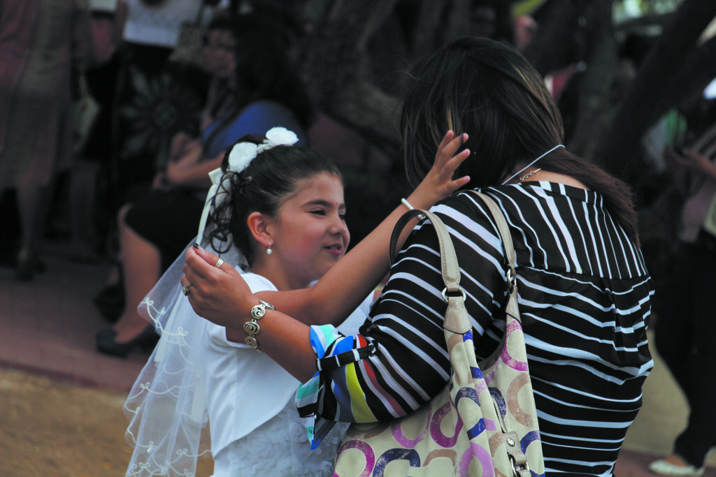 A newly confirmed Catholic, taking seriously her call to share her gifts, places her confirmation name badge on someone she loves outside of Our Lady of Perpetual Help Parish in Glendale April 25. (Ambria Hammel/CATHOLIC SUN)