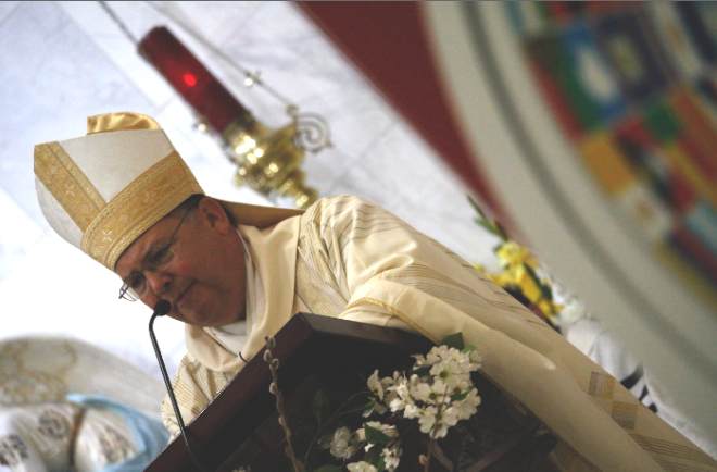 Bishop Nevares delivers his bilingual homily during the Diversity Mass April 25, but greeted Catholics in # other languages. A collage image of country flags — flanked by Vatican flags — reminded Catholics of the universality of the Church. (Ambria Hammel/CATHOLIC SUN)