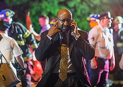 Philadelphia Mayor Michael Nutter speaks on a cellphone as emergency responders search for passengers following an Amtrak train derailment in Philadelphia May 12. (CNS photo/Bryan Woolston, Reuters)