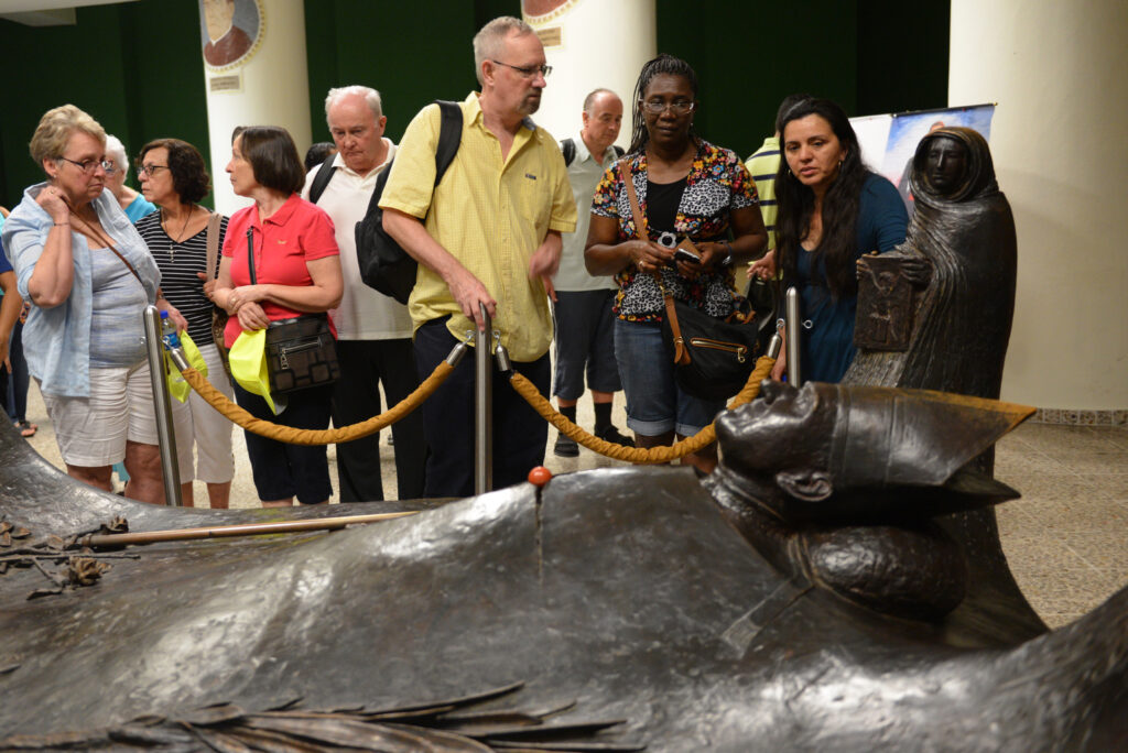 U.S. pilgrims stand near the tomb of Archbishop Oscar Romero in the cathedral in San Salvador May 21, two days before the beatification of the archbishop, who was shot by unidentified gunmen as he celebrated Mass March 24, 1980. (CNS photo/Lissette Lemus)