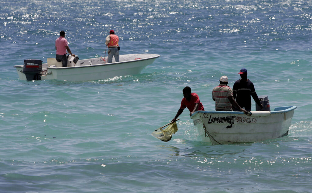 In this March 3, 2008 photo, environmental workers collect sea samples after an oil spill at Boca Chica, Dominican Republic. (CNS photo/Orlando Barria, EPA)