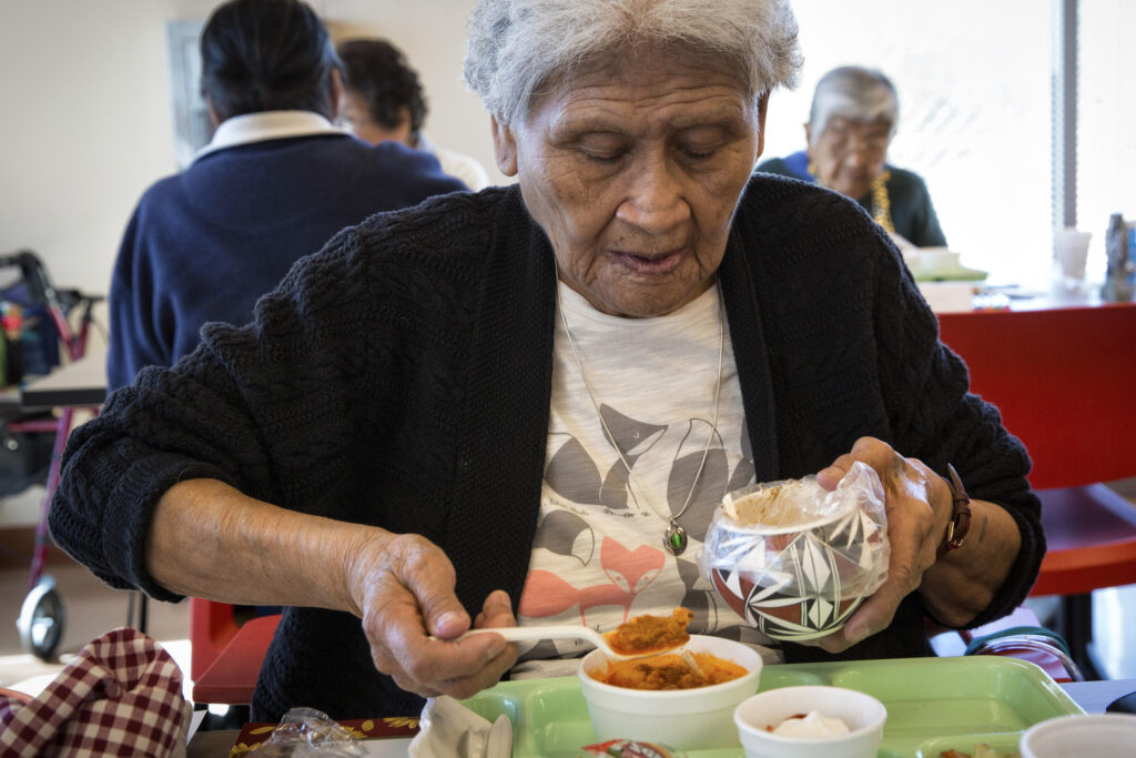 Marlinda Gonzales adds a small portion of her lunch to a communal bowl before her meal at the Kawaika Senior Center in Laguna Pueblo, N.M., in this 2014 file photo. The practice is one way Pueblo people give thanks for the food that sustains them. Pope Francis' long-anticipated encyclical on the environment was released at the Vatican June 18. (CNS photo/Nancy Wiechec)