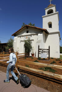 A schoolgirl makes her way past Santa Cruz Mission in Santa Cruz, Calif., May 18. (CNS photo/Nancy Wiechec)