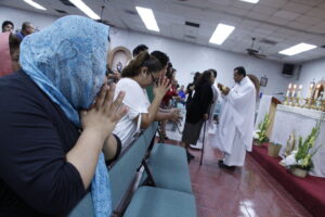 Parishioners at St. Martin de Porres in Phoenix pray during communion in June. Two-thirds of its weekend Masses are in Spanish. (Ambria Hammel/CATHOLIC SUN)