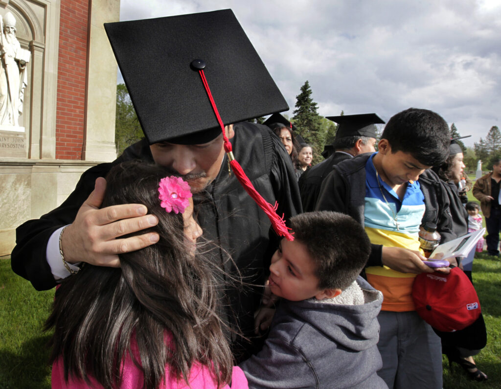 Mateo Vazquez, a graduate of the Lay Leadership Certificate Spanish program, gets a congratulatory hug following ceremonies at the academic convocation of the University of St. Mary of the Lake in Mundelein, Ill., May 11. (CNS photo/Karen Callaway, Catholic New World)