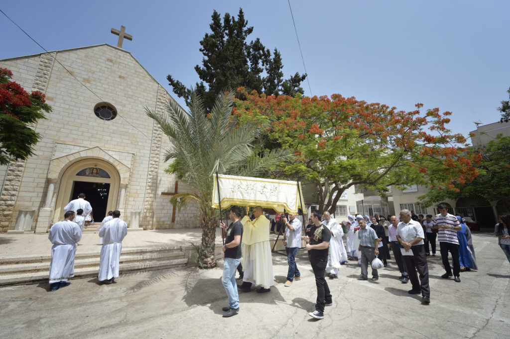 Father Jorge Hernandez leads a Corpus Christi procession outside Holy Family Catholic Parish in Gaza City, June 7. (CNS photo/Paul Jeffrey)