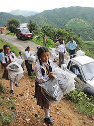 Students from Don Bosco School in Kathmandu, Nepal, carry books, bags and school suppliesl July 9 to a government-run school in Chaughare, that was affected by the April 25 earthquake. The magnitude 7.8 earthquake destroyed more than 25,000 classrooms in nearly 8,000 schools. (CNS photo/Anto Akkara)