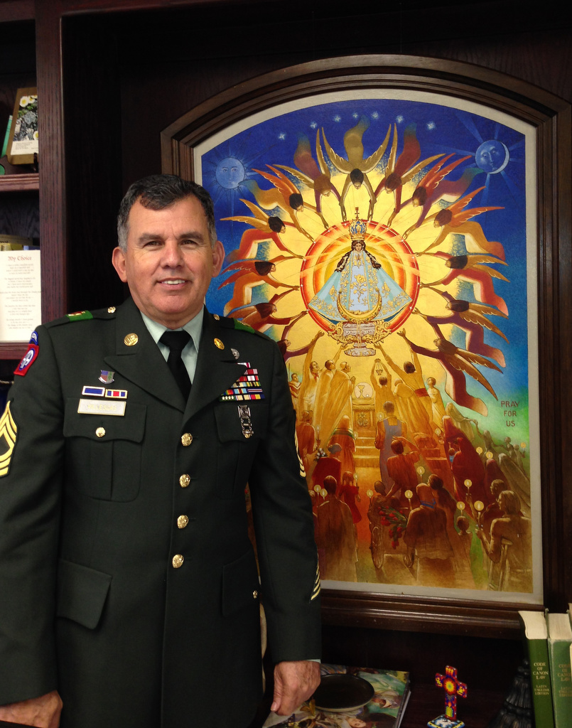 Retired Master Sgt. Pablo H. Villescas stands next to an image of Our Lady of San Juan del Valle. Villescas, who serves as the administrator of the Basilica of Our Lady of San Juan del Valle-National Shrine in San Juan, Texas, has worked at the shrine since he was in high school, starting out as a dishwasher in the cafeteria. (CNS photo/courtesy Fr. Amador Garza)