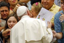 Pope Francis greets a child as he arrives to lead his weekly audience in Paul VI hall at the Vatican Aug. 5. (CNS photo/Giampiero Sposito, Reuters)