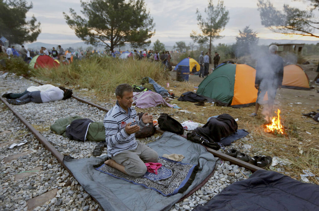 A Syrian refugee prays on a train track at the Greek-Macedonian border, near the village of Idomeni, Greece, Aug. 22. Catholic aid agencies have urged Europeans not to turn against migrants seeking refuge from Syria and other countries, in what media reports describe as the continent's greatest refugee movement since World War II. (CNS/Yannis Behrakis, Reuters)