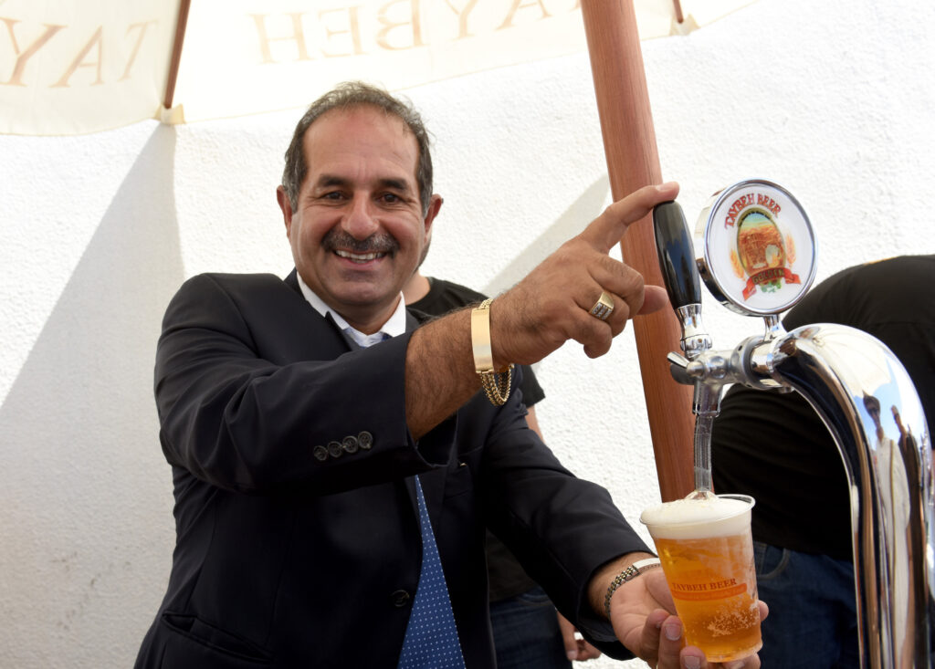Palestinian Christian Nadim Khoury, master brewer and co-founder of the Taybeh Brewery Company, pours a beer at the Taybeh Oktoberfest in the West Bank village of Taybeh Sept. 19. (CNS photo/Debbie Hill)