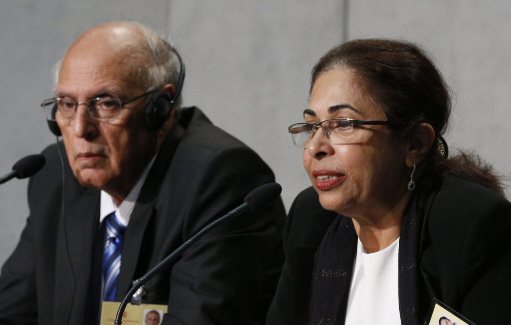 Penny Bajaj, accompanied by her husband Ishwar, speaks during a press briefing after the morning session of the Syond of Bishops on the family at the Vatican Oct. 12. The couple from Mumbai, India, are observers at the synod. (CNS/Paul Haring)