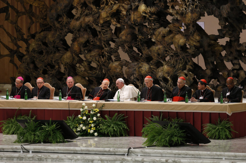 Pope Francis and leaders of the Synod of Bishops on the family and top officials from the synod's general council attend an event marking the 50th anniversary of the Synod of Bishops in Paul VI hall at the Vatican Oct. 17. The pope outlined his vision for how the entire church must be "synodal" with everyone listening to each other, learning from each other and taking responsibility for proclaiming the Gospel. (CNS photo/Paul Haring)