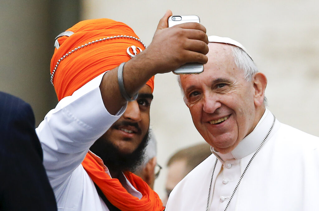 Pope Francis poses for a selfie with a member of the inter-religious community during his weekly audience in St. Peter's Square at the Vatican Oct. 28. (CNS photo/Stefano Rellandini, Reuters)