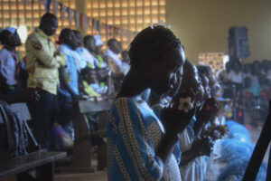 Young women pray during Mass Nov. 22 at a Catholic church adjacent to a camp for displaced persons in Bangui, Central African Republic. Pope Francis is scheduled to visit the camp during his Nov. 29-30 visit to Bangui. (CNS photo/EPA)