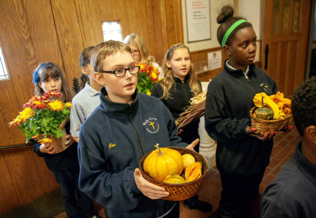 Holy Cross School fifth-graders Joseph Ashmead and Marguerite Kasinge join classmates in bringing Thanksgiving offerings to the altar during a Nov. 24 Thanksgiving Mass at Holy Cross Church in Rochester, N.Y. (CNS photo/Mike Crupi, Catholic Courier)