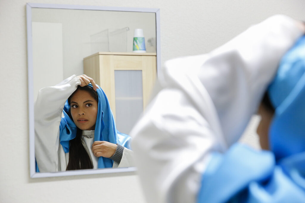 Kenia Salas, 17, adjusts her costume as she prepares to play the role of Mary in a traditional "posada" commemoration near the U.S.-Mexican border in Nogales, Mexico. The re-enactment recalls Mary and Joseph's search for shelter before the birth of Christ. (CNS photo/Nancy Wiechec) 