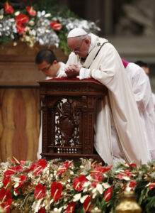 Pope Francis kneels in prayer as he celebrates Christmas Eve Mass in St. Peter's Basilica at the Vatican Dec. 24. (CNS photo/Paul Haring)