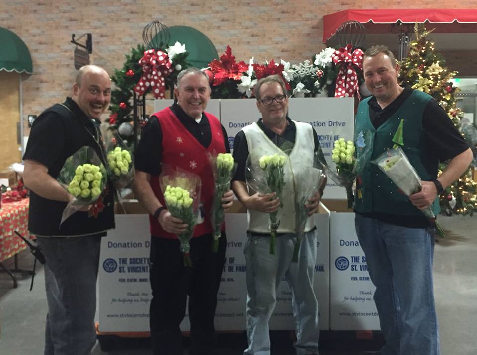 Some of the Arizona Flower Market crew show the Christmas spirit they will spread with the community's help. Donors who drop off a new toy or five cans of food for the Society of St. Vincent de Paul can take home a dozen white roses for free. (courtesy photo)