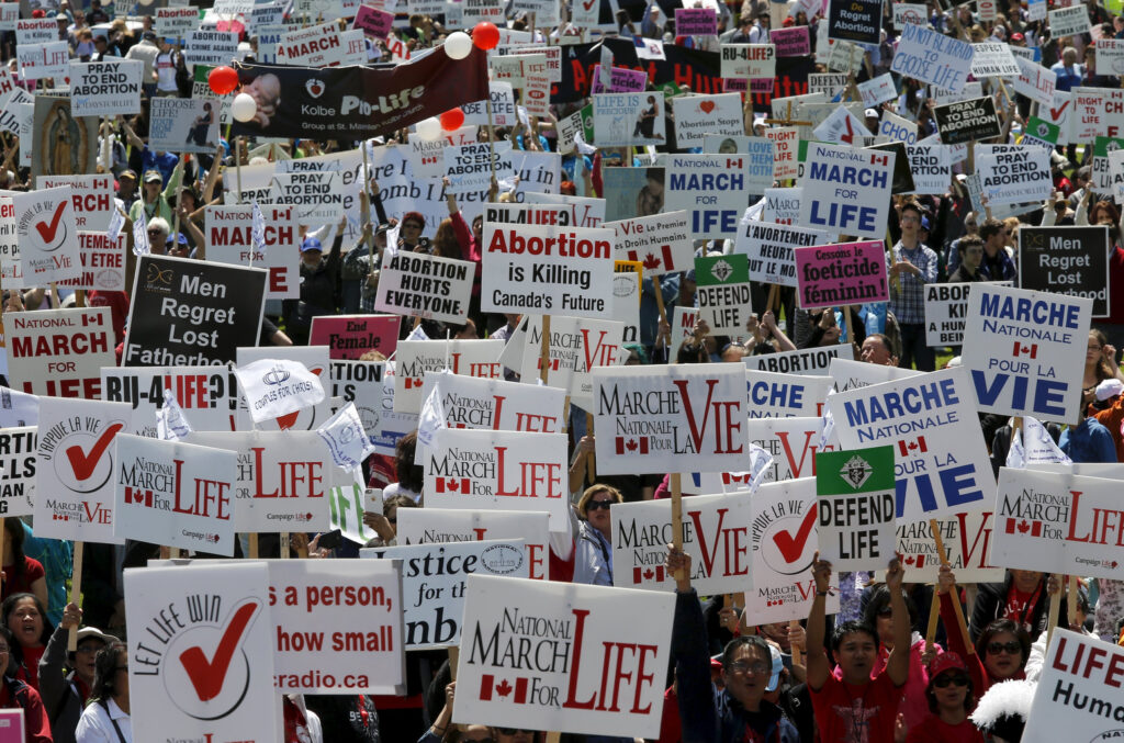Demonstrators hold signs during a May 14, 2015 pro-life protest on Parliament Hill in Ottawa, Ontario. (CNS photo/Chris Wattie, Reuters)