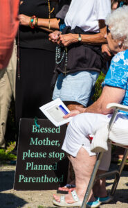 Pro-life supporters recite the rosary with Bishop David L. Ricken of Green Bay, Wis., during a prayer service in late August 2015 outside of a Planned Parenthood facility in Grand Chute, Wis. The abortion facility announced in early October that it was suspending abortion services for six months. (CNS photo/Sam Lucero, The Compass)
