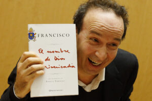 Italian actor Roberto Benigni holds a copy of the book, "The Name of God Is Mercy," during its presentation to journalists in Rome Jan. 12. The book is compiled from an interview Pope Francis did with Italian journalist Andrea Tornielli. (CNS photo/Paul Haring) 