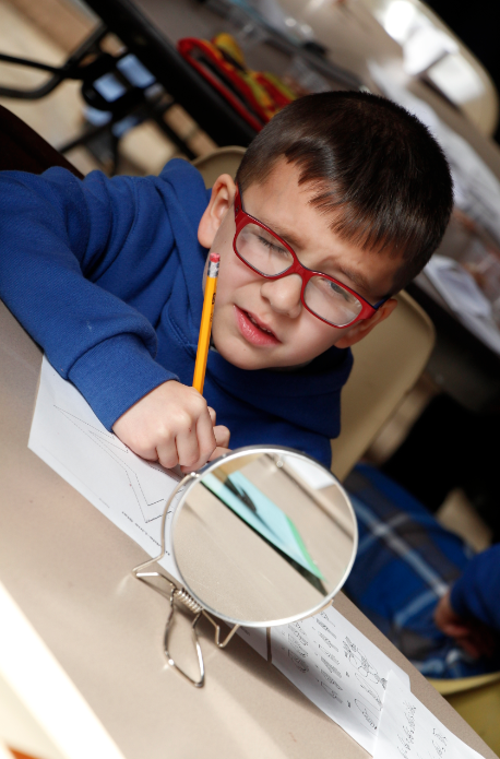 A St. Gregory student tries to trace a star shape while looking in a mirror during a "Celebrating Differences" event Jan. 8. Several simulation stations helped students better understand classmates who have learning disabilities, mobility challenges or difficulty hearing or seeing. (Ambria Hammel/CATHOLIC SUN)